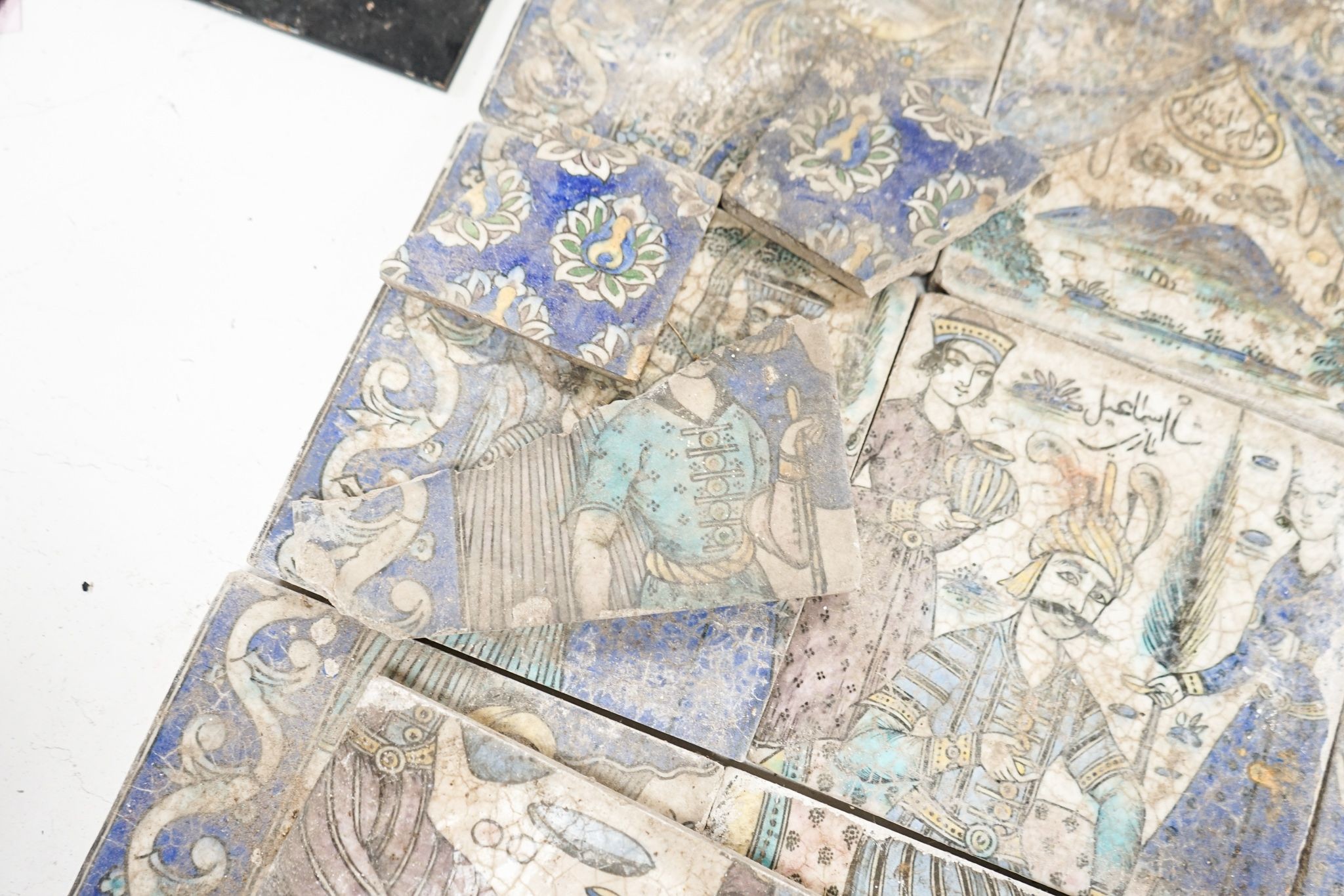 A Persian fritware tile panel, late 19th/early 20th century, incomplete, 55cm wide and another tile fragment